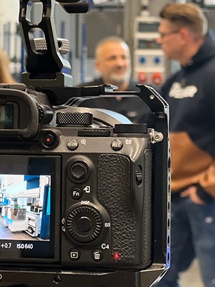 Filmproduktion: Kamera im Vordergrund, Gesprächspartner im Hintergrund