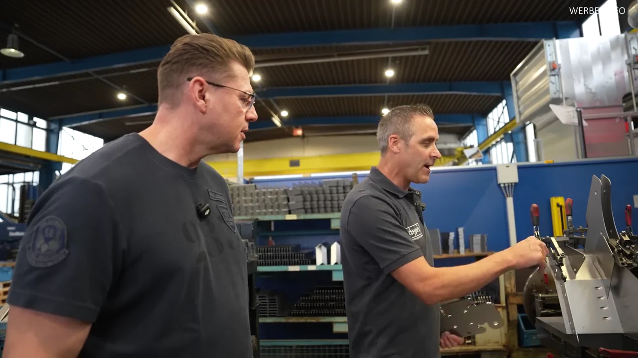 Igor Welder im Gespräch mit einem Scheppach-Mitarbeiter an einer Maschine in der Fertigung